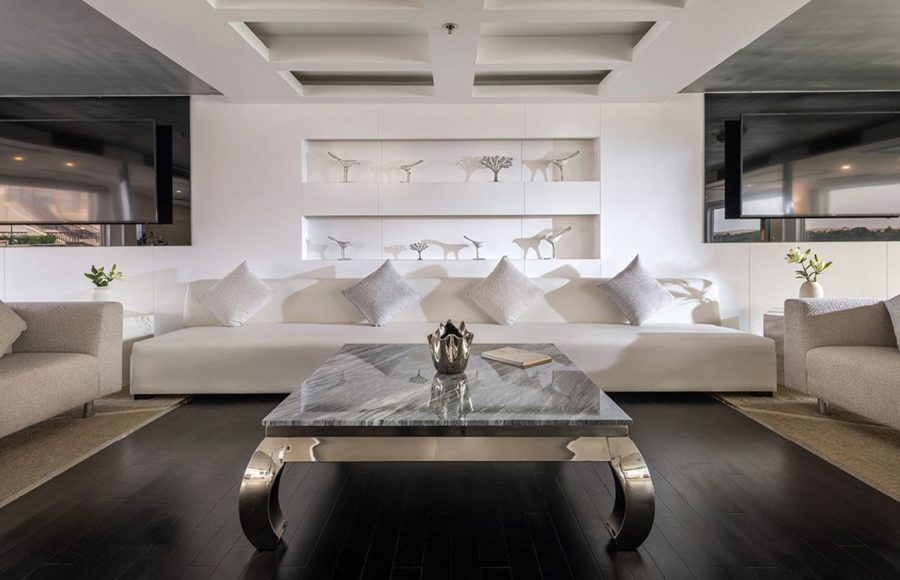 Formal dining room on the MS Farah cruise ship with set tables, white columns, and purple-backed chairs.