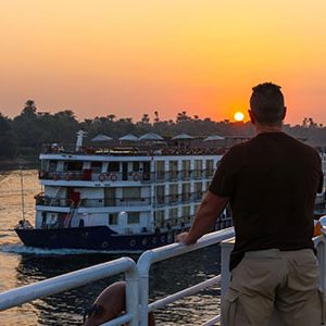 Man leaning over the railing at sunset in the Nile river through his egypt and turkey luxury tour 17 days nile cruise hurghada cappadocia