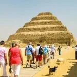 A group of tourists walking toward the Step Pyramid of Djoser during a Memphis and Saqqara day trip in Egypt
