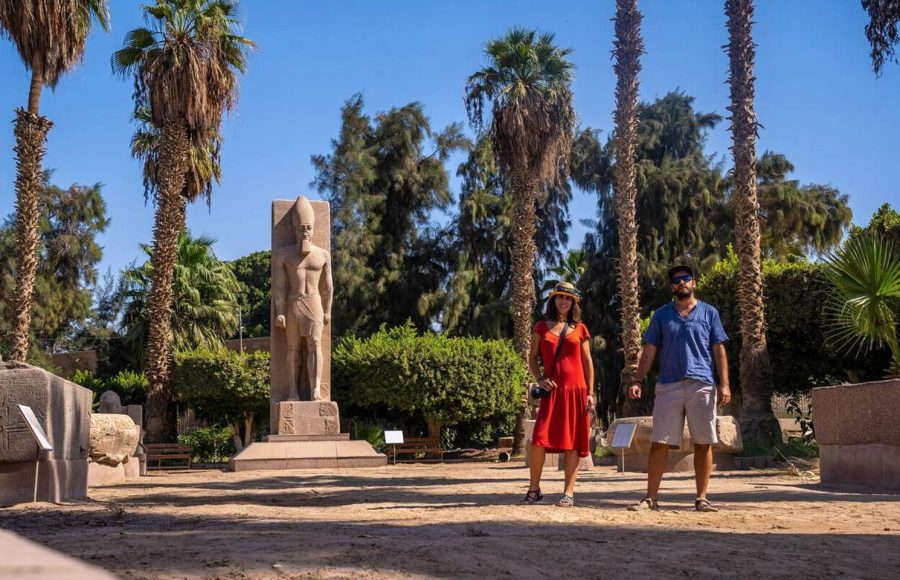 Couple standing next to a statue of Ramses II in Memphis during a wonderful Memphis day trip from Cairo