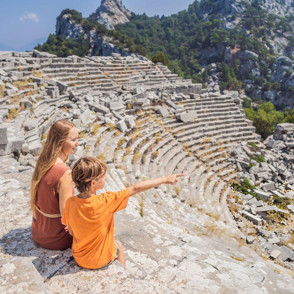 Mother and son tourists explores Stunning Ancient Theater of Hierapolis Ancient City Turkey