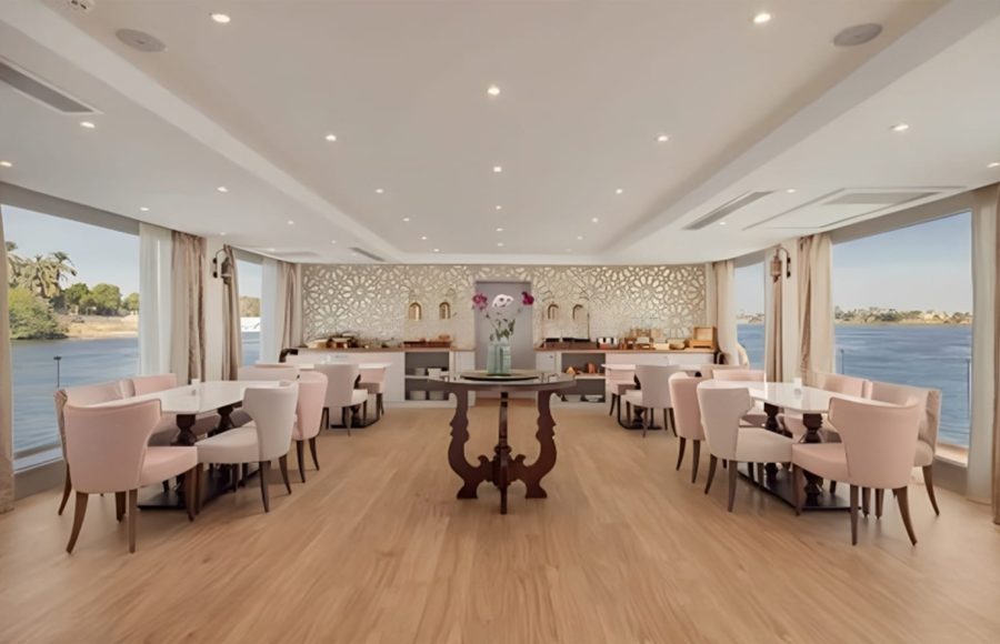 Elegant Nile cruise dining room with light pink chairs and panoramic windows.