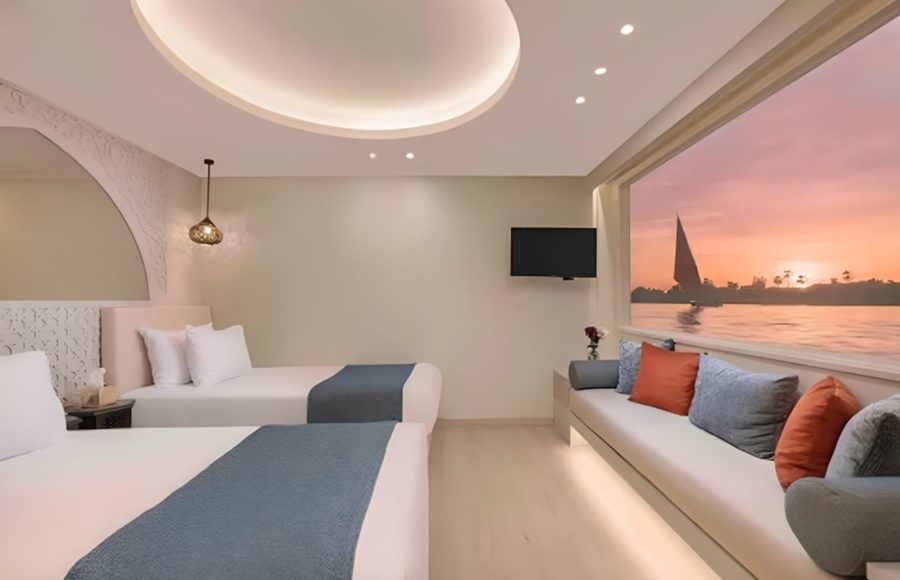 Nile cruise twin cabin with window seat and sunset view.