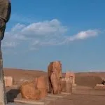 Fragmented statues standing in a row against a blue sky, perfect for a Nile Delta day trip