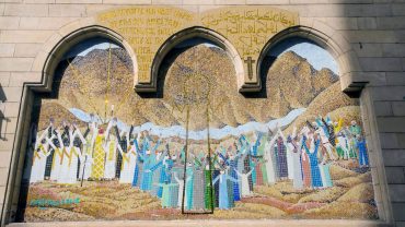 An ornate outdoor mosaic depicting a religious scene on the wall of the Coptic Hanging Church in Cairo, Egypt.