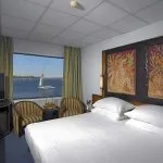 Cabin on a cruise ship with a double bed and a window view of the Nile.