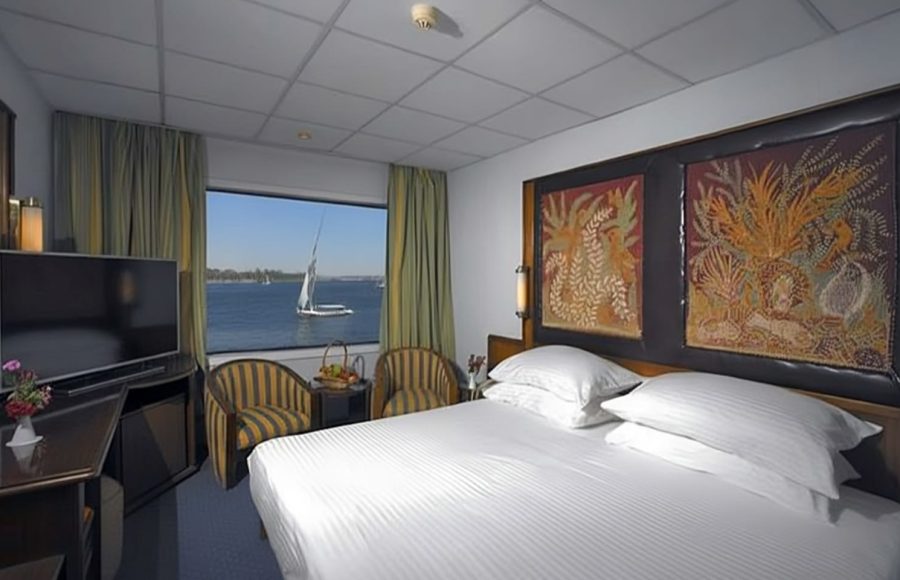 Cabin on a cruise ship with a double bed and a window view of the Nile.