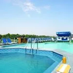 Swimming pool and sun loungers on a cruise ship's sundeck.