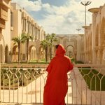 Rear-view-of-a-female-tourist-in-traditional-authentic-Moroccan-clothes-visiting-and-admiring-the-Hassan-II-mosque