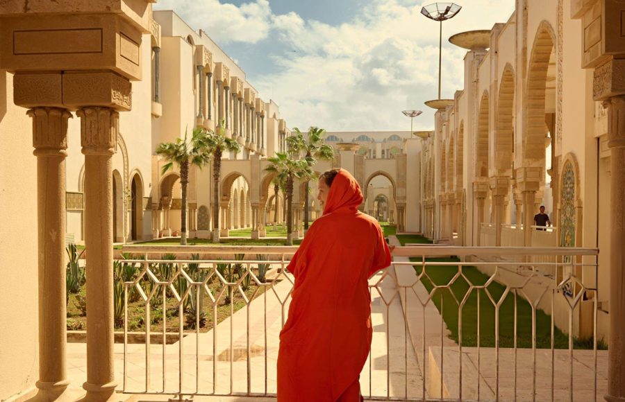 Rear-view-of-a-female-tourist-in-traditional-authentic-Moroccan-clothes-visiting-and-admiring-the-Hassan-II-mosque