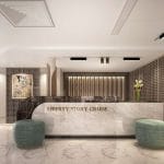 Modern cruise ship reception desk made of white marble, labeled "Liberty Story Cruise," flanked by two round turquoise ottomans.