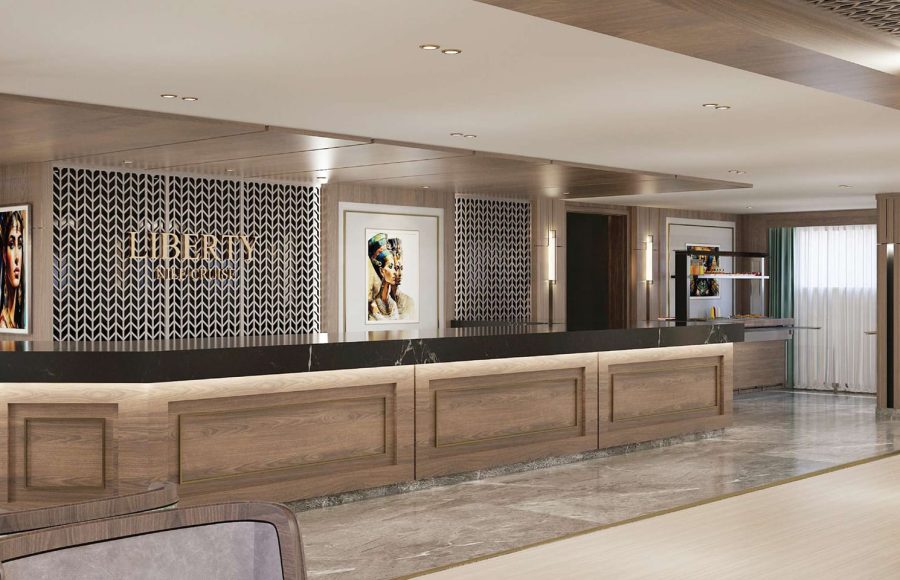 Long, wood-paneled cruise ship reception counter with a black top, framed by patterned screens and Egyptian-themed artwork.