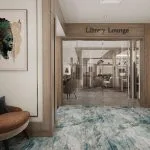 Entrance to the "Liberty Lounge" on a cruise ship, featuring an abstract blue carpet, wood paneling, a seating area, and a large portrait of an Egyptian queen.