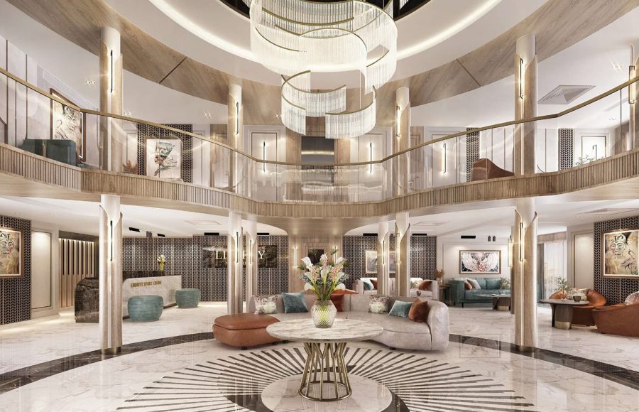Multi-story luxury cruise lobby with a central chandelier, marble floor with a radial pattern, and modern lounge seating areas.