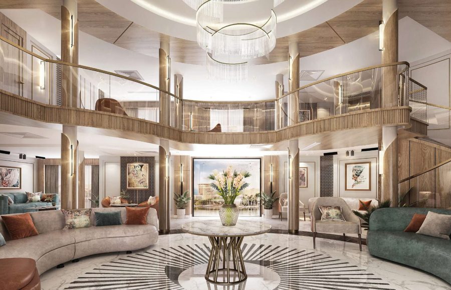 Luxurious, circular two-story cruise ship atrium/reception lobby with modern furniture, wood and brass accents, and a large chandelier.