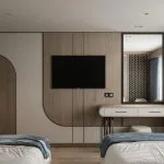 Modern twin-bed cabin interior with a flat-screen TV, wood paneling, and a vanity mirror.