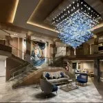 Grand atrium and reception area of MS Royal Signature with a large blue crystal chandelier and a mural.