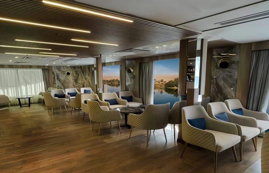Interior seating area on MS Royal Signature with quilted beige chairs, wood floor, and scenic windows.