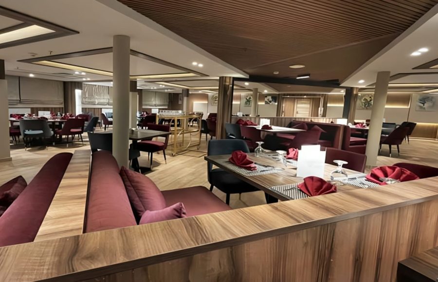 Elegant dining room on MS Royal Signature Nile cruise ship with maroon seating and wood accents.
