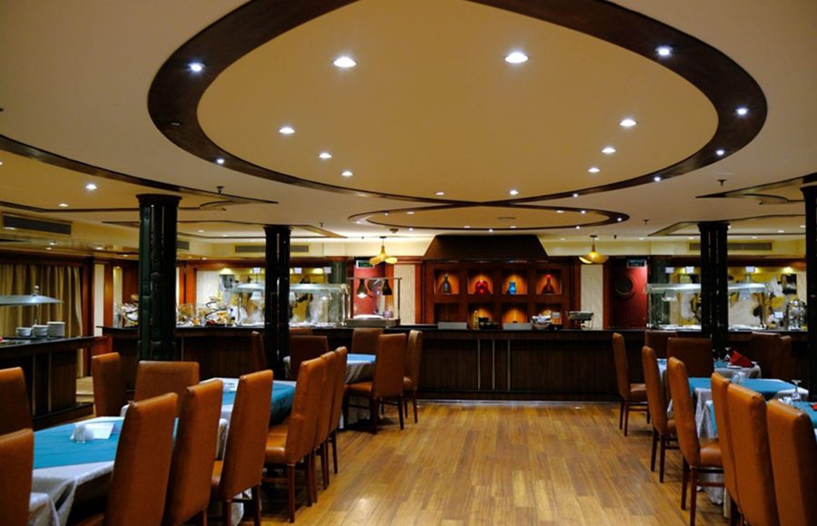 Dining hall on the Royal Viking Nile Cruise featuring a buffet counter and oval ceiling lights.