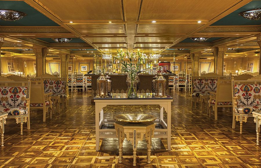 The elegant main lounge and bar area with patterned chairs on the luxurious Sphinx Nile Cruise