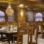 The luxurious restaurant on the Sphinx Nile Cruise with ornate wooden chairs and scenic Nile views at sunset