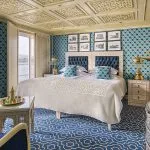 A beautifully decorated Suite with a comfortable bed and river views on the Sphinx Nile Cruise