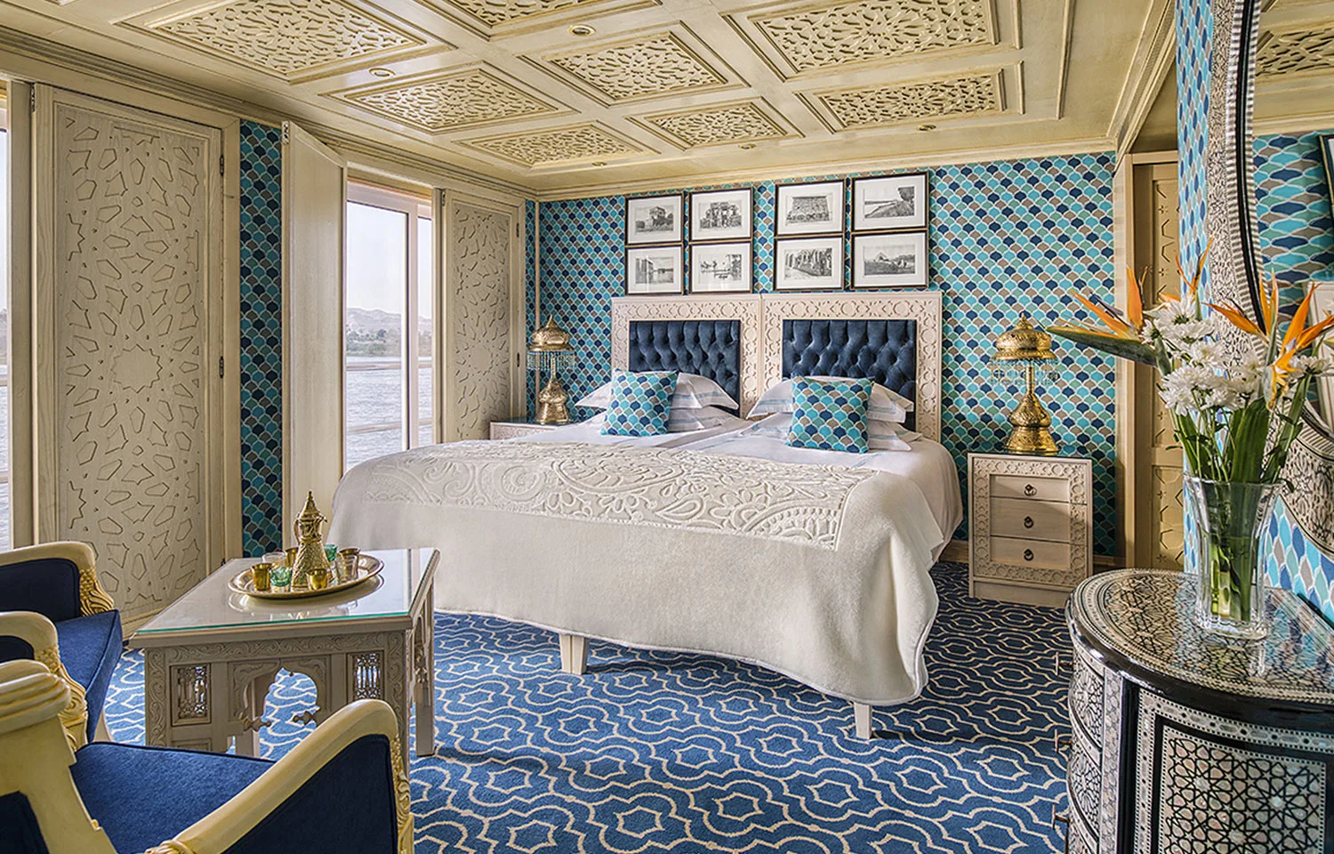 A beautifully decorated Suite with a comfortable bed and river views on the Sphinx Nile Cruise