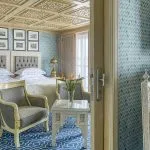 An elegant Suite with twin beds, sitting area, and Egyptian-inspired decor on the Sphinx Nile Cruise