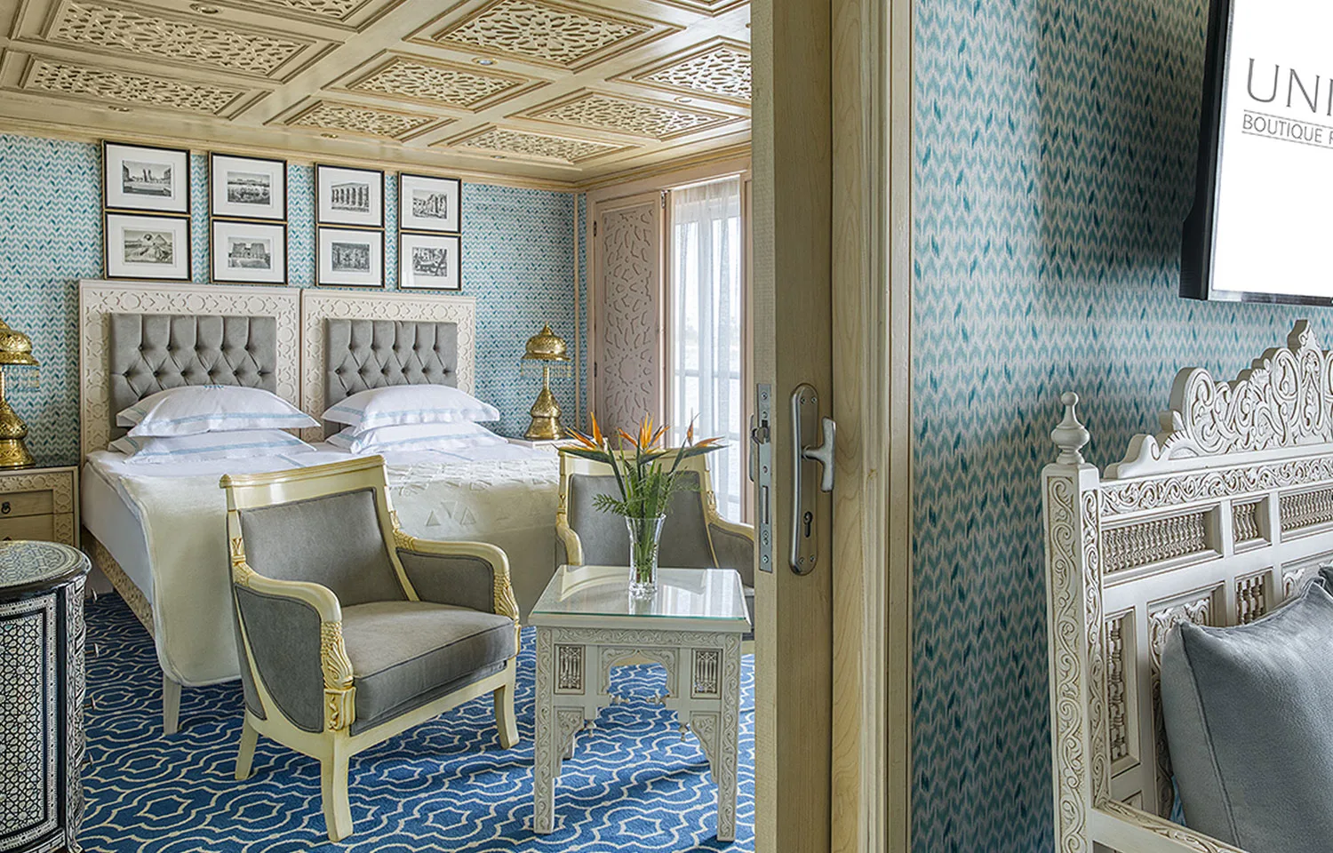 An elegant Suite with twin beds, sitting area, and Egyptian-inspired decor on the Sphinx Nile Cruise