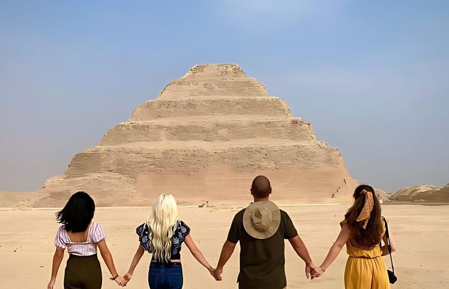 Friends holding hands in front of the monument on a Saqqara Step Pyramid tour