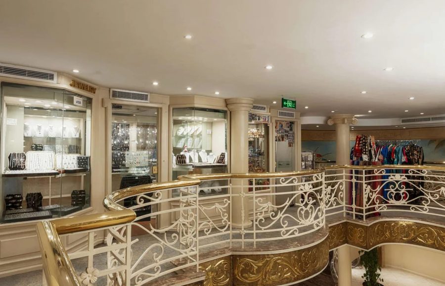 Onboard shopping center with jewelry displays and clothing racks near a curved staircase.
