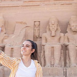 Smiling happy woman taking a selfie as tourist in Abu Simbel in Egypt at her 12 day Egypt Morocco with Nile cruise and Abu Simbel tour