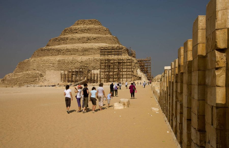 Tourists walk along the perimeter wall approaching the Step Pyramid of Saqqara tour