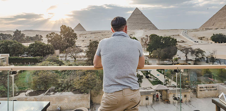 Stylish man against the background of the Giza pyramids 1
