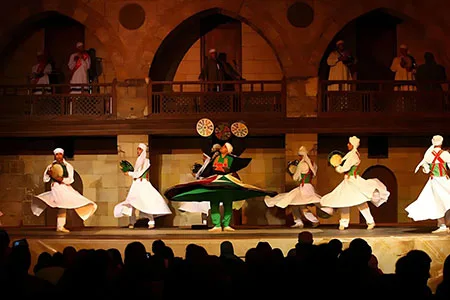 A group of performers in white robes during a Cairo cultural dance show at the historic El Ghouri complex