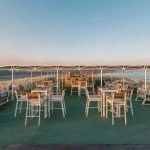 Outdoor bar and seating area on a Nile cruise ship at sunset.