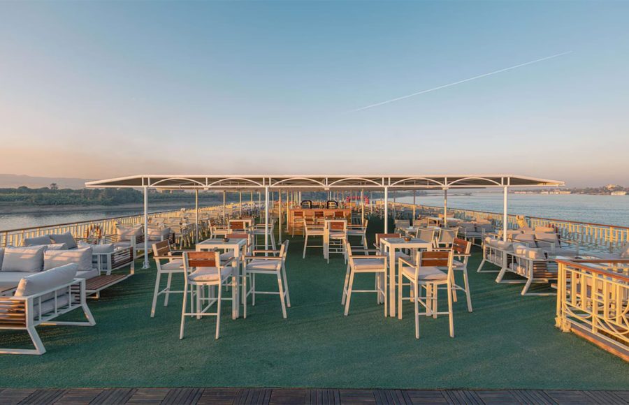 Outdoor bar and seating area on a Nile cruise ship at sunset.