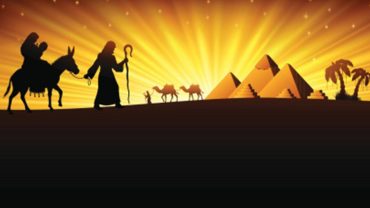 A silhouette illustration of the Holy Family's trip into Egypt, showing Mary and Jesus on a donkey, Joseph, and a caravan of camels in front of the Pyramids and a bright sunrise.