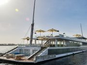 Full view of the Kazazian Arax Dahabiya on the Nile with white sun umbrellas and glass railings