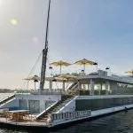 Full view of the Kazazian Arax Dahabiya on the Nile with white sun umbrellas and glass railings