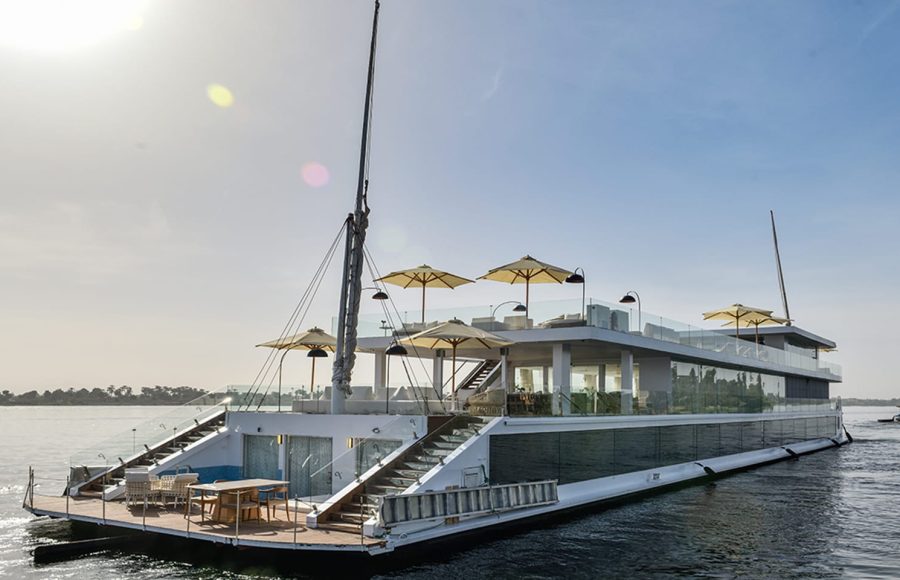 Full view of the Kazazian Arax Dahabiya on the Nile with white sun umbrellas and glass railings