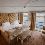 Luxurious king suite on Tosca Nile Cruise with river view.