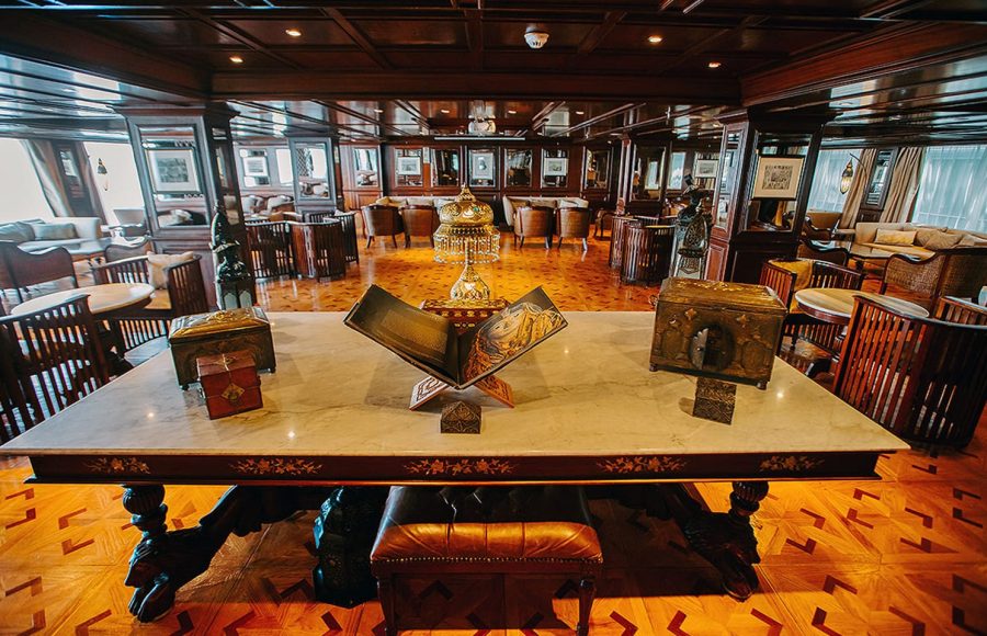 Interior of a dark wood lounge on a Nile cruise ship with a decorative centerpiece table.