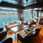 Interior of a luxurious dark wood lounge with panoramic windows on a Nile cruise ship.