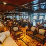Interior of a dark wood lounge and bar area on a Nile cruise ship.