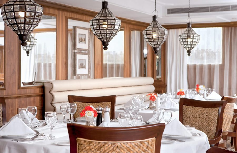 Dark wood library interior on a Nile cruise ship with seating areas and bookshelves.
