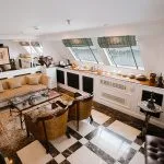 Modern luxury Royal Suite living room on a Nile cruise with panoramic windows and marble floor.