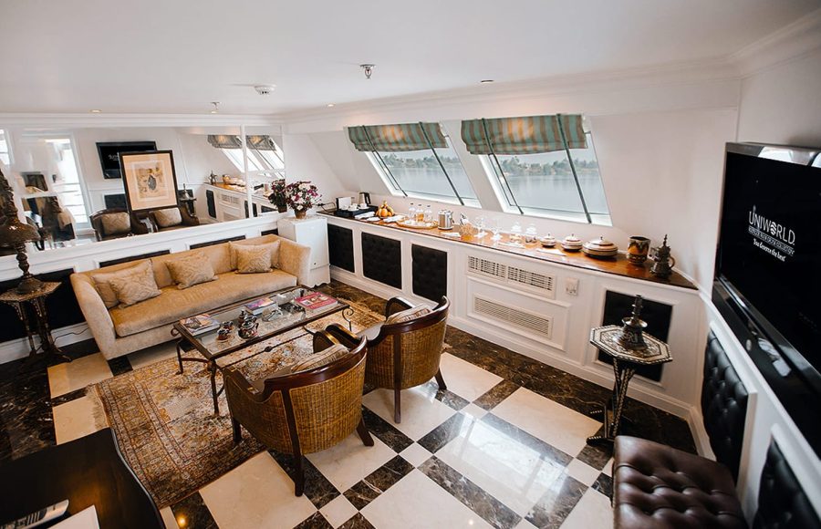 Modern luxury Royal Suite living room on a Nile cruise with panoramic windows and marble floor.