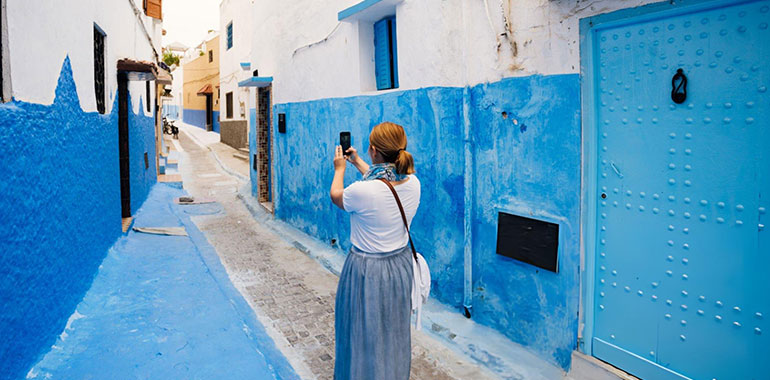 Tourist Woman taking photo while walking trough alley in Rabat Old Medina Morocco